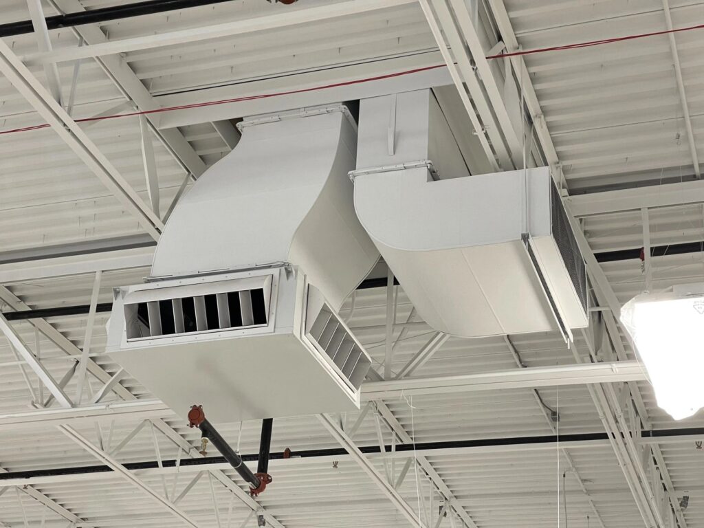 White industrial ductwork and vents mounted on a ceiling
