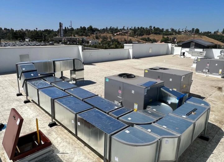 Extensive rooftop HVAC units and silver ductwork are seen on a building.