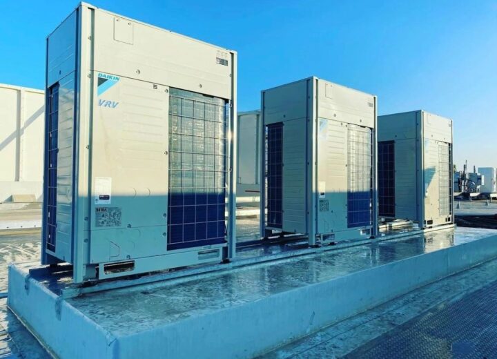 Several large, rectangular HVAC units are installed on a light-colored rooftop.